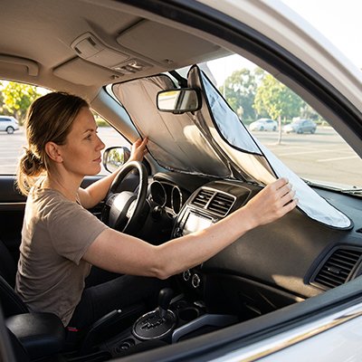 Pare soleil voiture dame installant pare brise avant