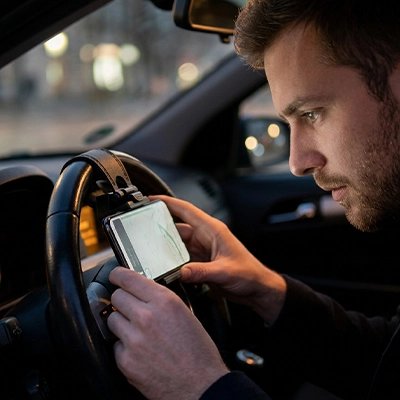 Support téléphone voiture homme consulte son téléphone fixé sur volant voiture 