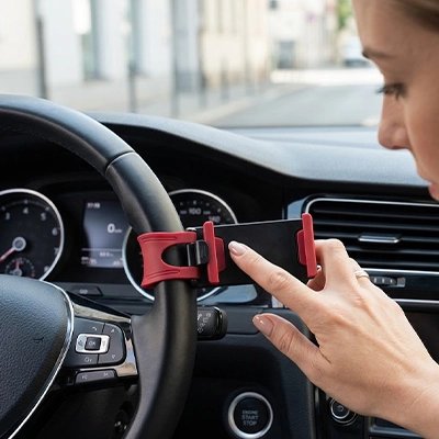 Support téléphone voiture rouge femme qui fixe sur volant voiture 